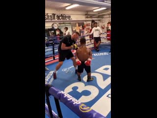 a short boxer is stuffing a steel press