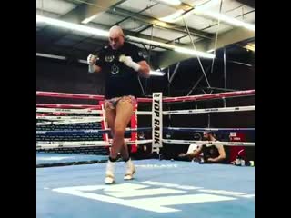 tyson fury lit up in the ring in multi-colored shorts