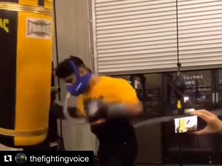 mikey garcia works in an oxygen mask on a heavy bag