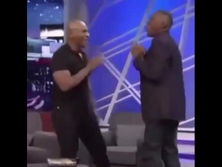 mike tyson shows his peekaboo pendulum technique to the presenter.