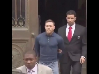 conor mcgregor leaves the police station in handcuffs.