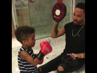 andre ward holding his son on his paws.